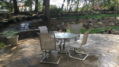 A table and four chairs on a stone patio Photo
