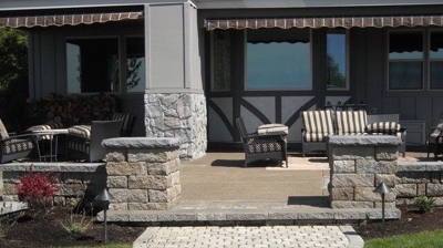 A patio with two short brick columns and a small half circle stone hardscaping Photo