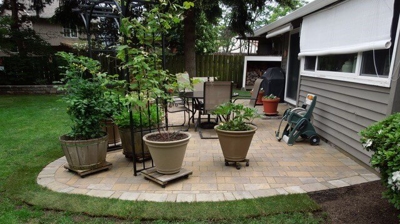 Stone hardscaping with potted plants in a backyard Photo