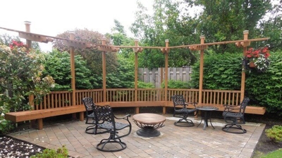 Stone hardscaping with patio furniture on it and a wooden frame behind it Photo